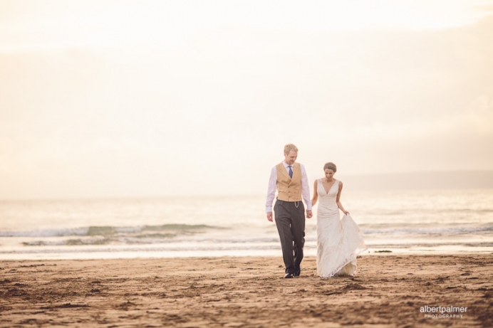 lucy and tim walking on the beach at their wedding in devon