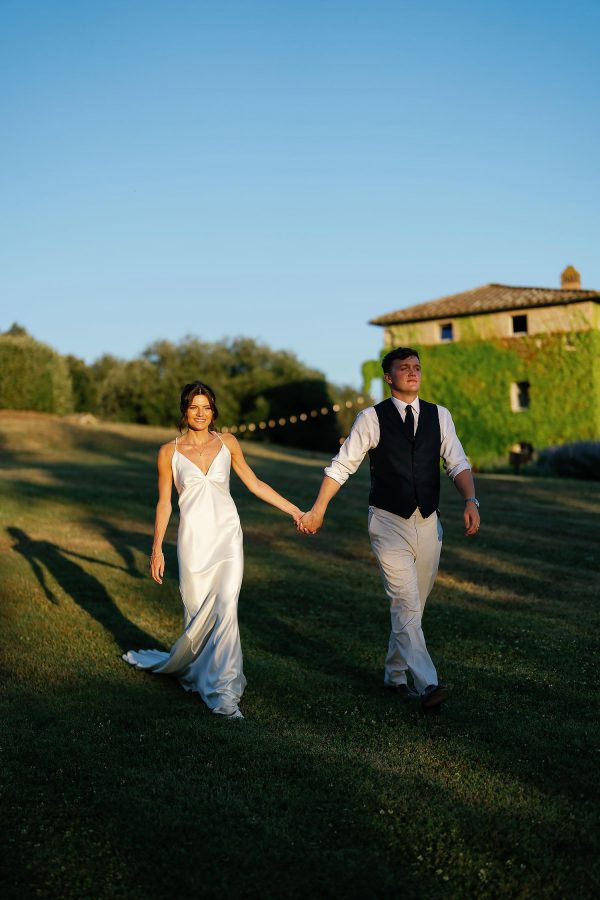 bride and groom walking in to the sun
