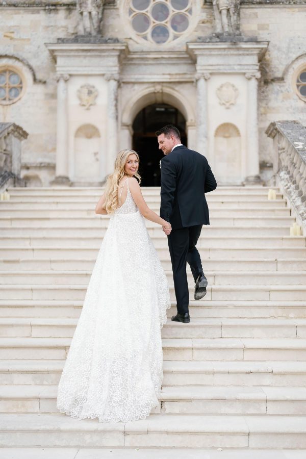 bride and groom walking outside Lulworth Castle