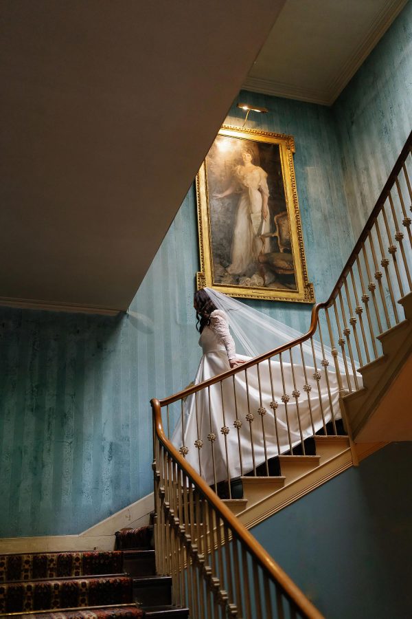 bride walking down stairs in St Giles House
