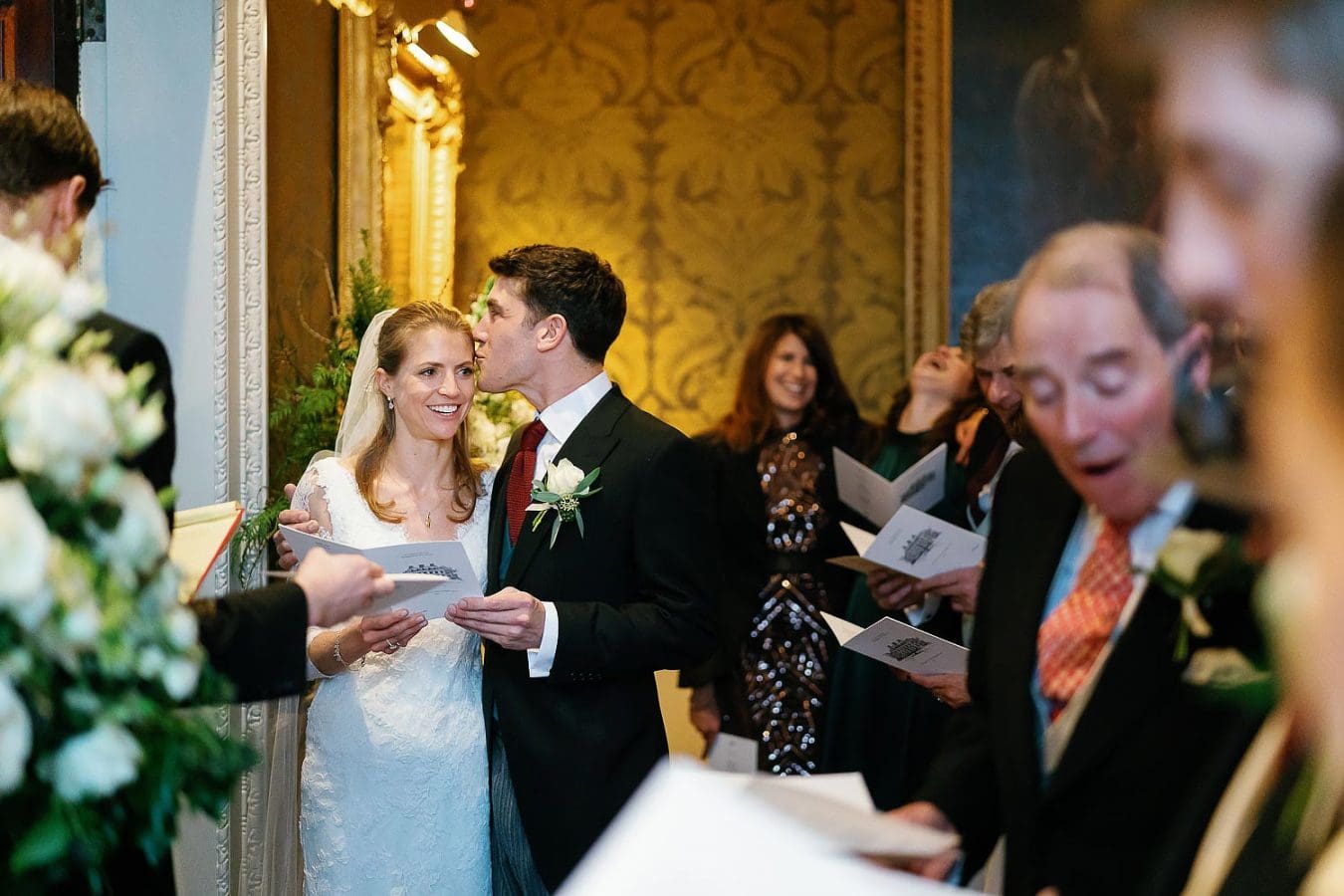 groom kissing bride on head