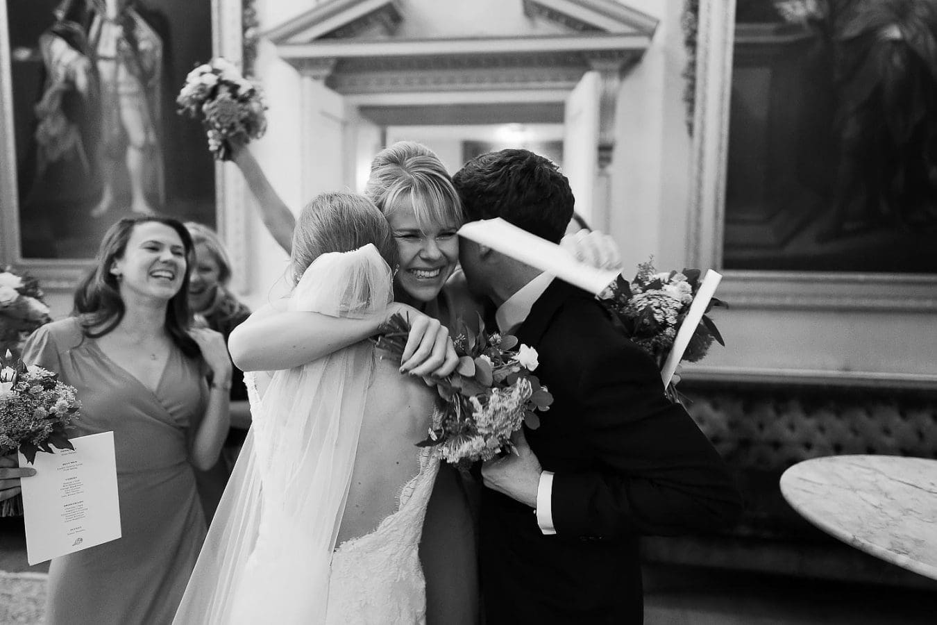 wedding guest hugging bride and groom