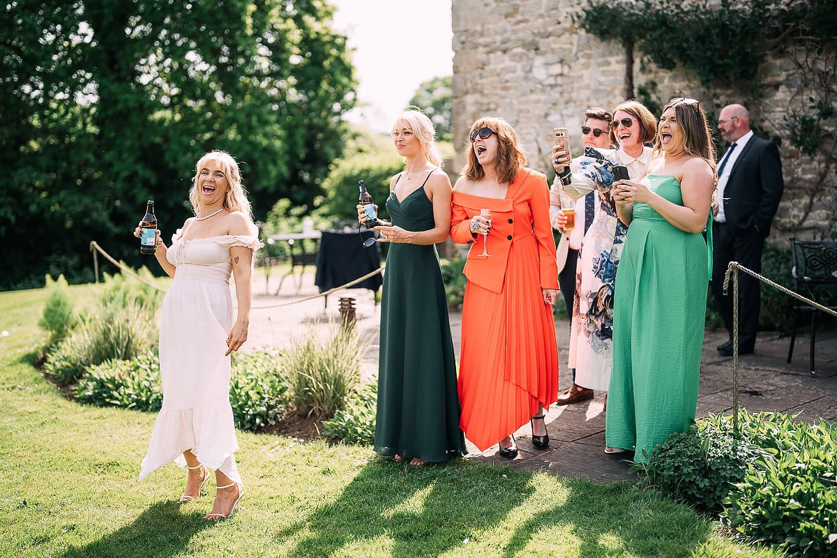wedding guests enjoying drinks in sunshine