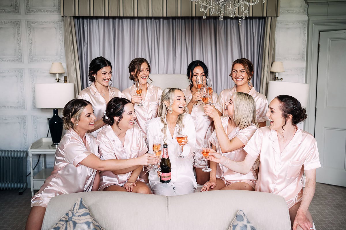bride and bridesmaids celebrating on bed