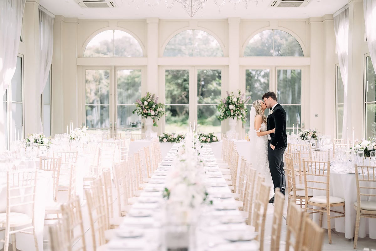 bride and groom kissing inside Clevedon Hall orangery