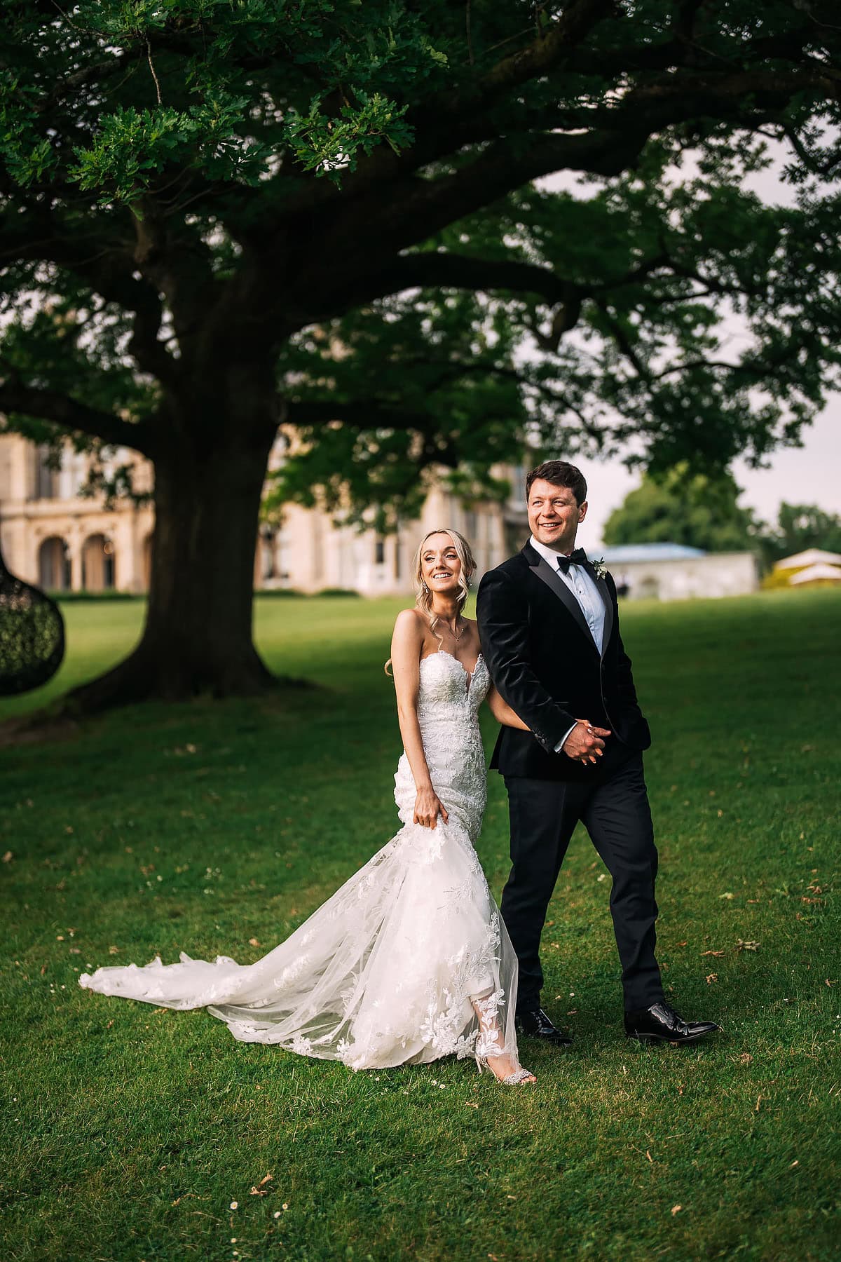bride and groom walking in Clevedon Hall grounds