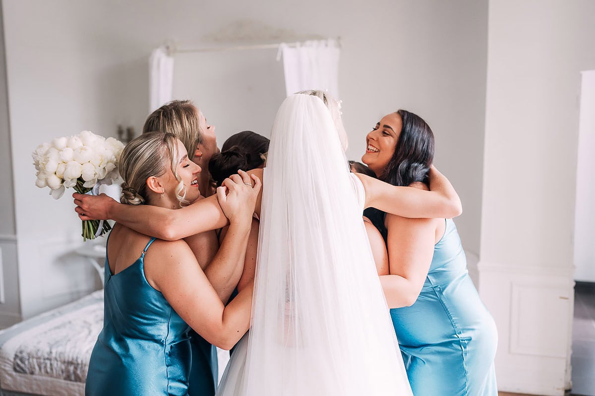 bride and bridesmaids hugging