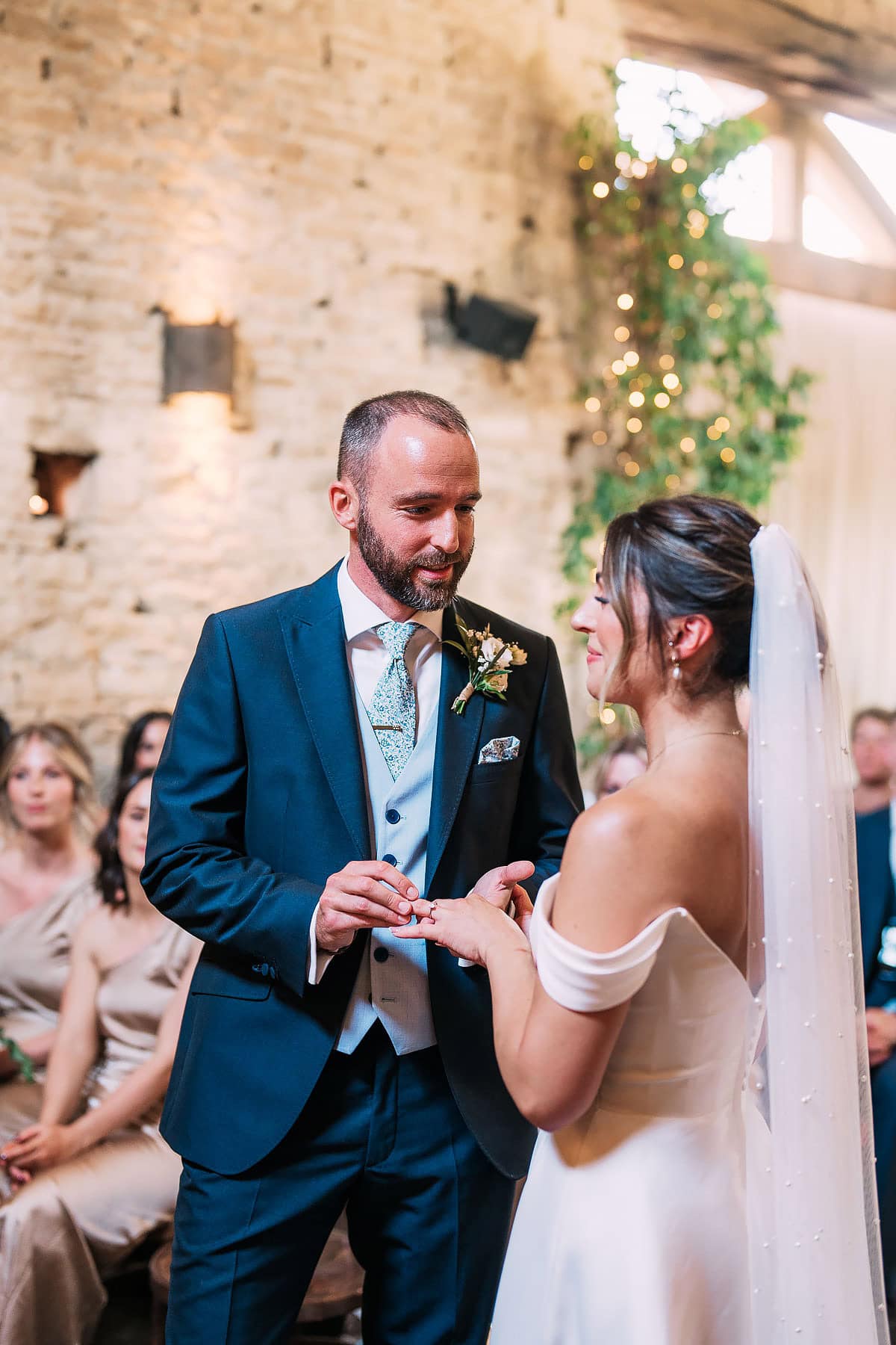 photo of groom putting on bride's ring