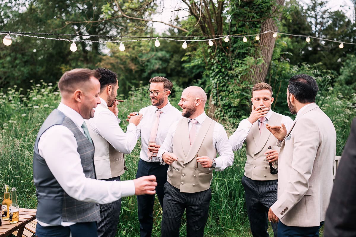 groom and friends celebrate wedding with cigars