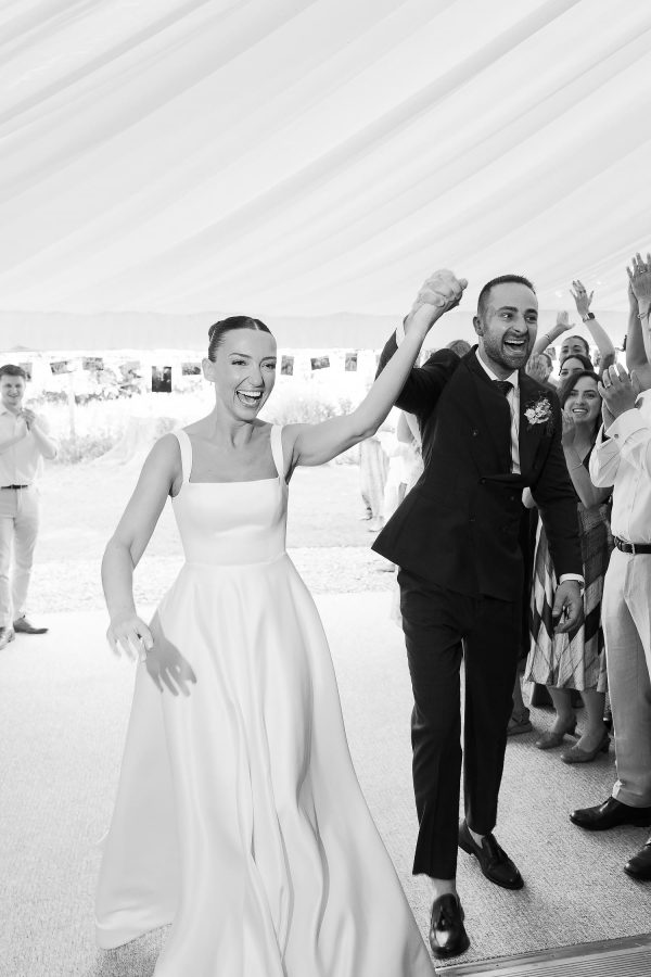 bride and groom walking in to deans court marquee