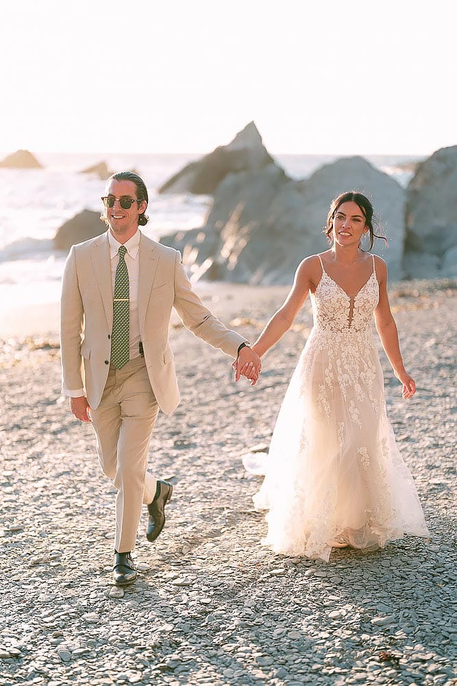 bride and groom walking on beach