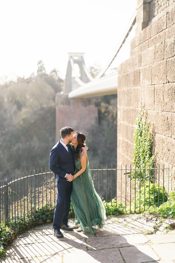 bride and groom by wedding in front of Clifton suspension bridge