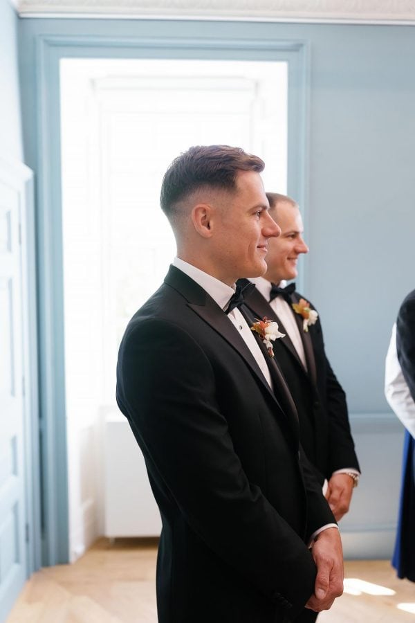 groom watching bride walk down the aisle